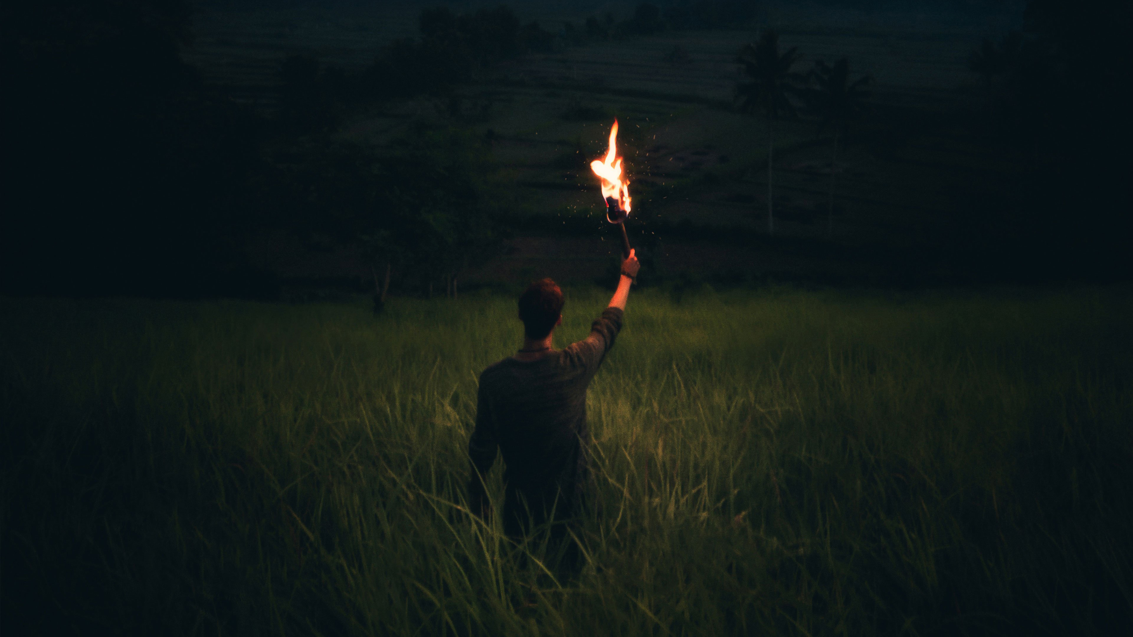 Раз горят огни. Человек факел. Человек с факелом в темноте. Мужик с факелом. Факел во тьме.