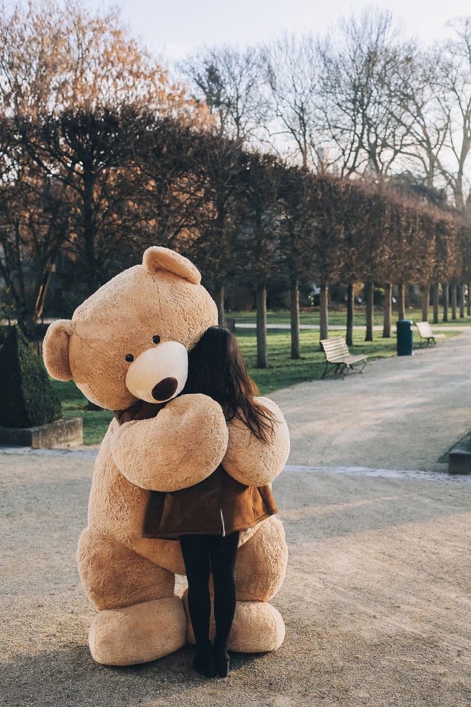 girl hugging big teddy bear